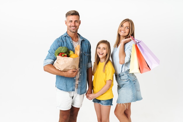 Photo caucasian family woman and man with daughter holding food products and shopping bags isolated on white