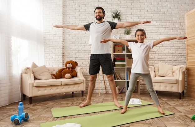 Caucasian Father And Daughter Do Stretch Exercise At Home