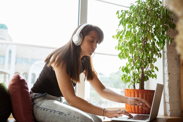 Caucasian female singer during online concert at home insulated and quarantined,