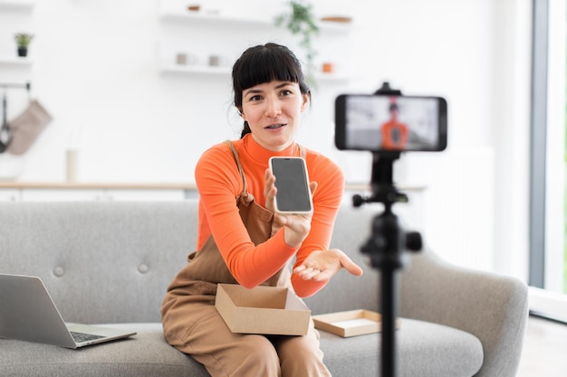 caucasian female unpacking smartphone during online review session