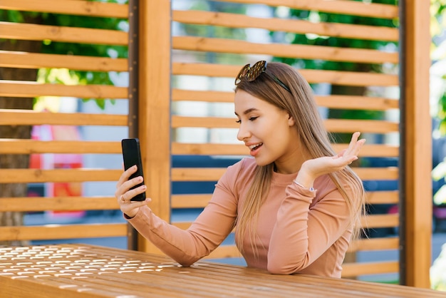 Caucasian friendly girl Chinese lady smiling on the phone webcam woman with a mobile gadget