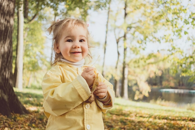 Caucasian girl child portrait in autumn garden.