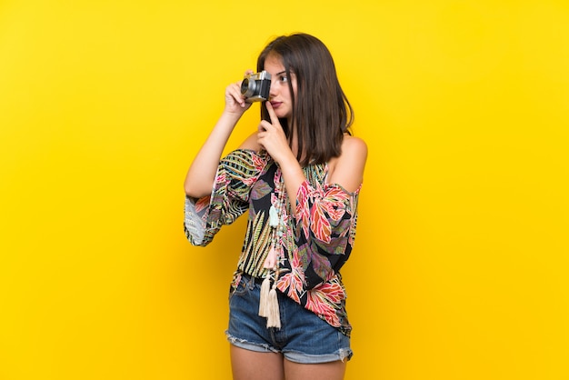 Ragazza caucasica in abito colorato in possesso di una macchina fotografica