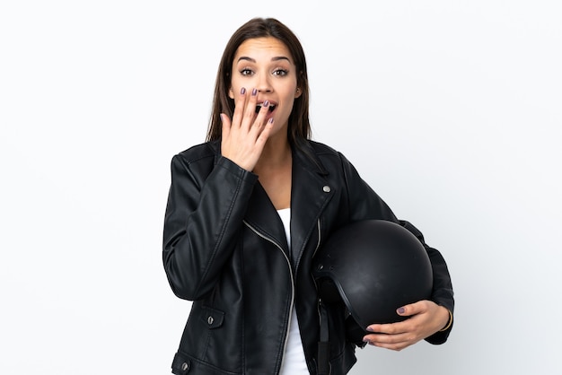 Caucasian girl holding a motorcycle helmet on white background with surprise facial expression