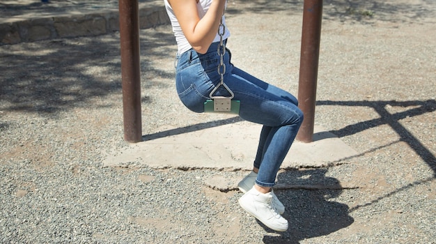 Caucasian girl is swinging on a swing