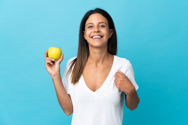 Caucasian girl isolated with an apple and happy