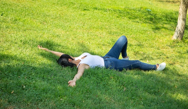 写真 屋外で草の上に横たわっている白人の女の子