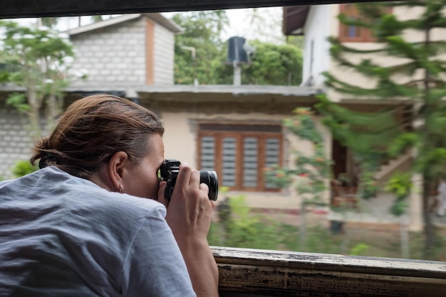 Photo caucasian girl making photos from train window while treavelling in sri lanka