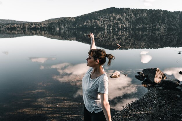 Photo caucasian girl in sunglasses in profile standing with arms outstretched calm and relax breathing