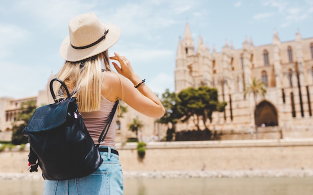 caucasian girl tourist in hat exploring new city at summer