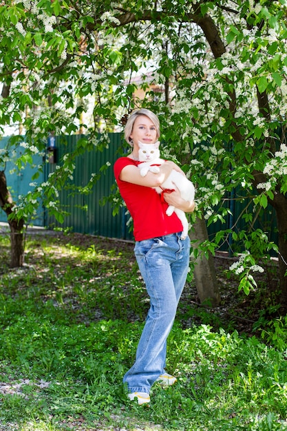 Caucasian girl walking in the park with her cat