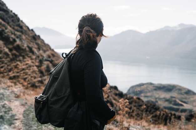 Photo caucasian girl with a backpack and a black tshirt with a ponytail in her hair and beautiful earrings