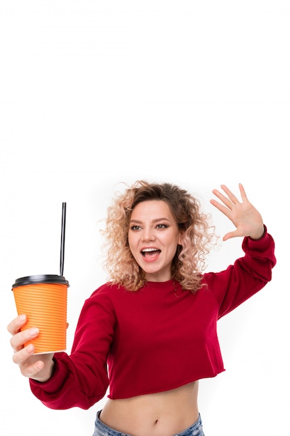 Caucasian girl with curly fair hair drinks coffe and smiles, portrait isolated