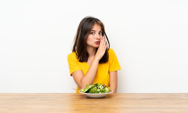 Caucasian girl with salad whispering something