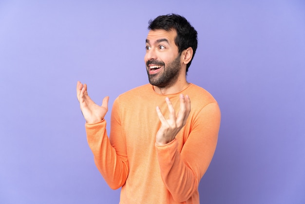 Caucasian handsome man over isolated purple wall with surprise facial expression