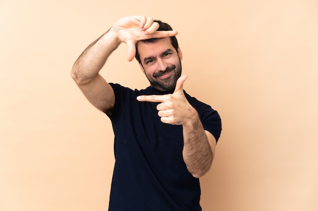 Photo caucasian handsome man over isolated wall focusing face. framing symbol