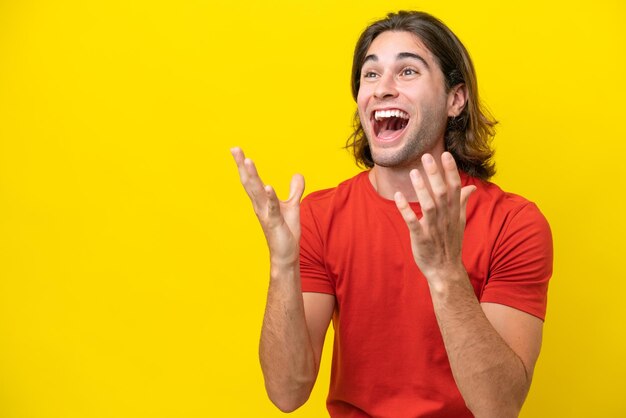 Caucasian handsome man isolated on yellow background with surprise facial expression