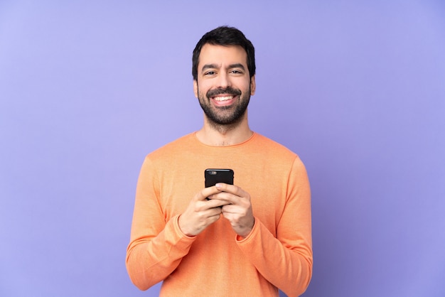 Caucasian handsome man sending a message with the mobile