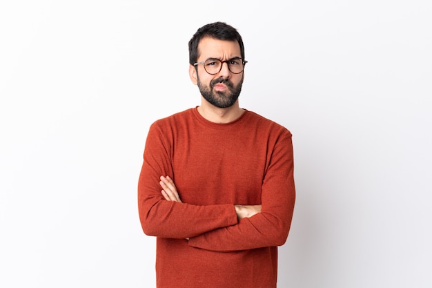 Caucasian handsome man with beard over isolated white wall feeling upset