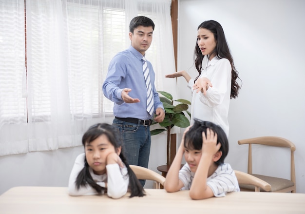 Caucasian husband argument with asian wife with their son and daughter unhappy and upset, social problems concept