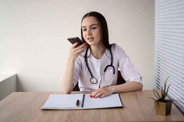 caucasian lady doctor sitting at her working table the concept of consulting a remotely. 