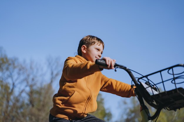 かごで自転車に乗る白人の小さな男の子