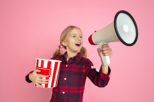 ピンクのスタジオの壁の映画館のコンセプトに白人の女の子の肖像画