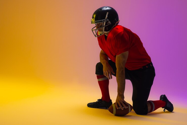 Photo caucasian male american football player holding ball with neon yellow and purple lighting