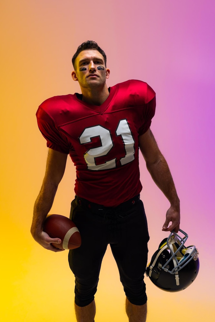 Photo caucasian male american football player holding helmet and ball with neon yellow and purple lighting