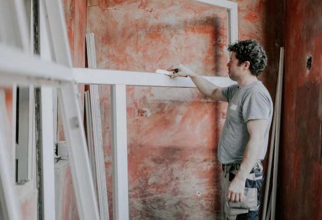 Caucasian male builder clean the window frame