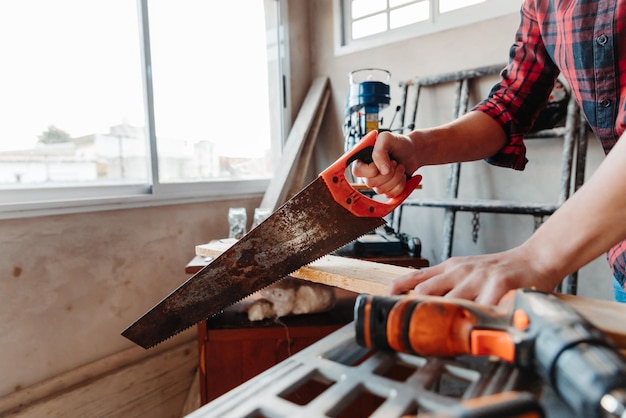 Caucasian male carpenter cutting wood while working in a workshop