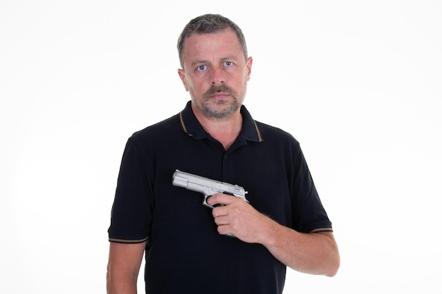 Кавказский мужчина держит пистолет на белом фоне