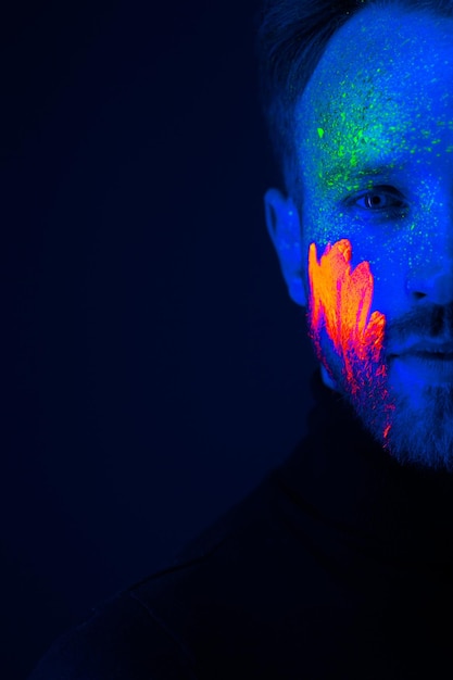 Caucasian male model with blacklight paint