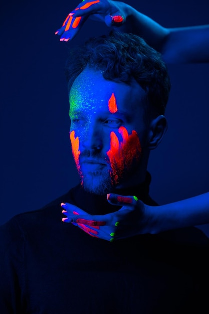 Caucasian male model with blacklight paint
