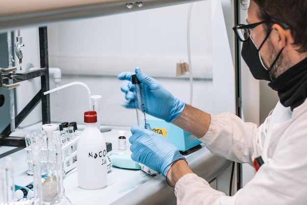 Caucasian male scientist hold test tube in bright lab on study experiment