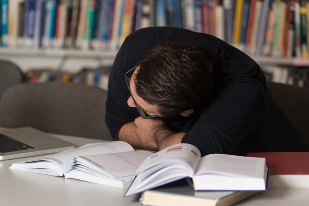 図書館で寝ている白人の男子学生