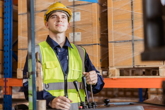 Caucasian male worker working in warehouse goods store inventory staff moving producs pallet shipping management with folk lift truck