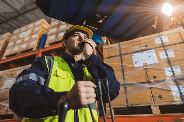 Caucasian male worker working in warehouse goods store inventory staff moving producs pallet shipping management with folk lift truck