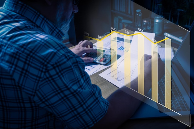 Caucasian man analyzing the level of expenditures and investments Overprinted graph with a histogram