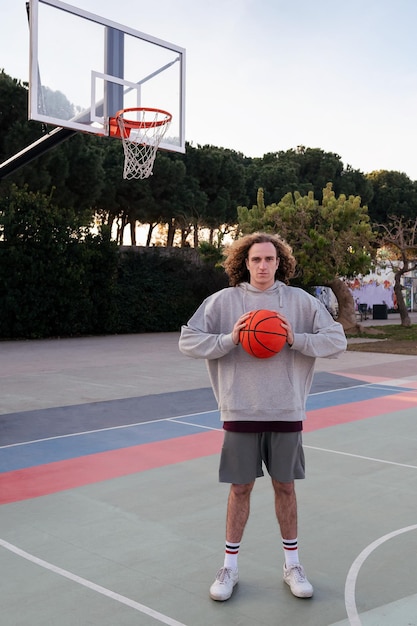 Caucasian man on a basketball court holding a ball in his hands concept of urban sport in the street copy space for text