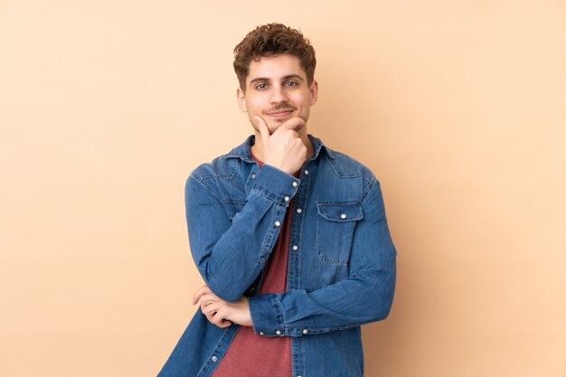 Caucasian man on beige wall laughing