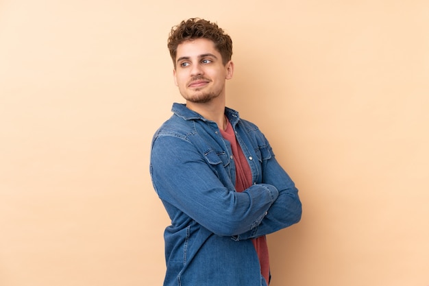 Caucasian man on beige wall laughing