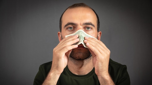 Caucasian man blowing nose on dollar