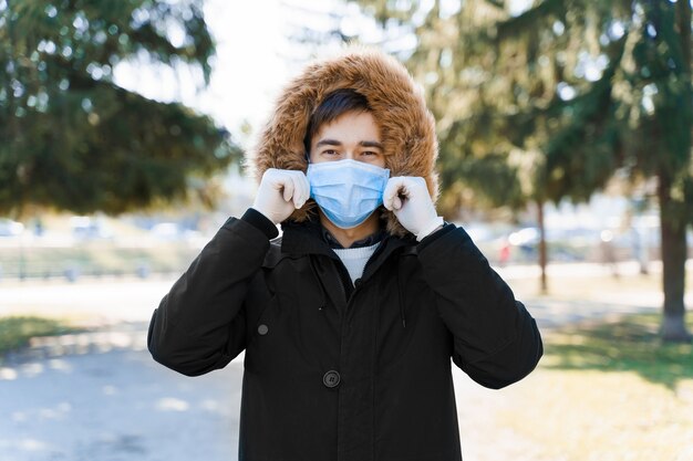 Caucasian man in blue medical mask dreses sterile mask on his face