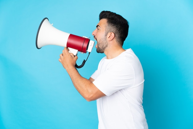 Caucasian man over blue shouting through a megaphone to announce something in lateral position