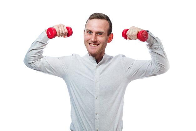 Caucasian man businessman, a teacher involved in sports. He is holding a red dumbbell. He is wearing a shirt. Emotional portrait. Isolated on white background