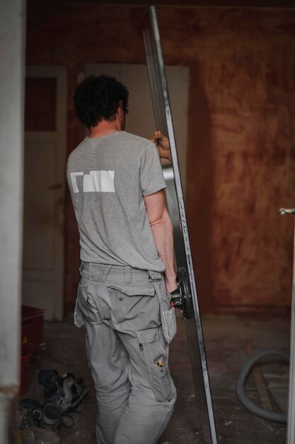 Caucasian man carries a window glass with a glass jack