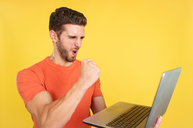 Caucasian man celebrating while looking at the laptop