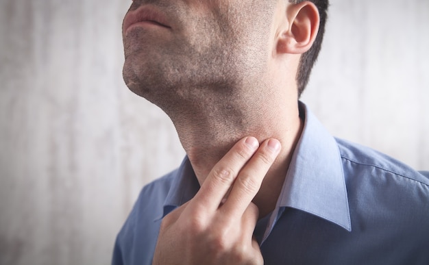 Caucasian man checking pulse in office.