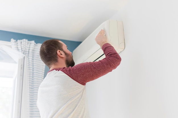 Caucasian man cleaning air conditioner